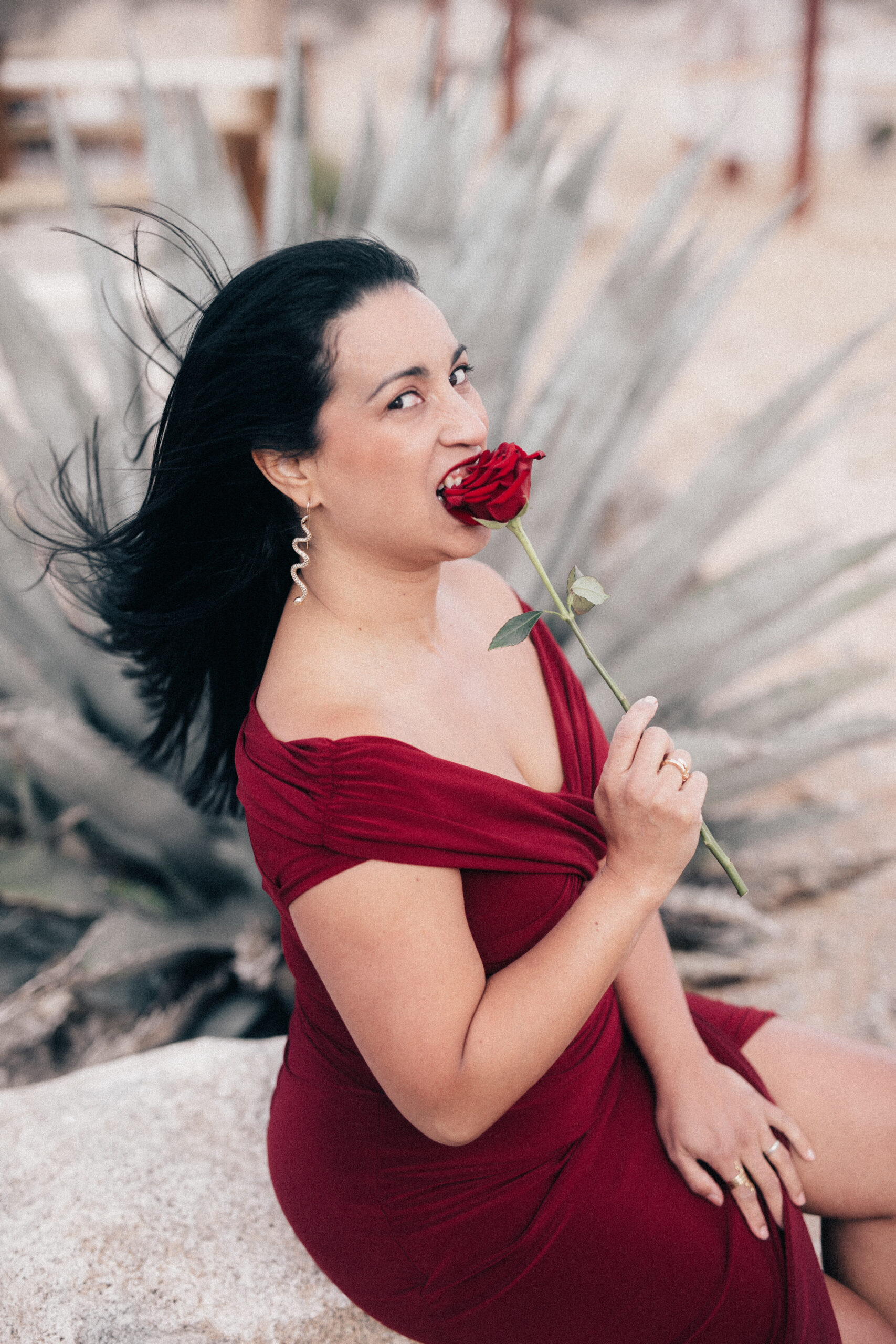 Jessy Furniel bites a red rose calling women to awaken your black panther and become the raw woman.