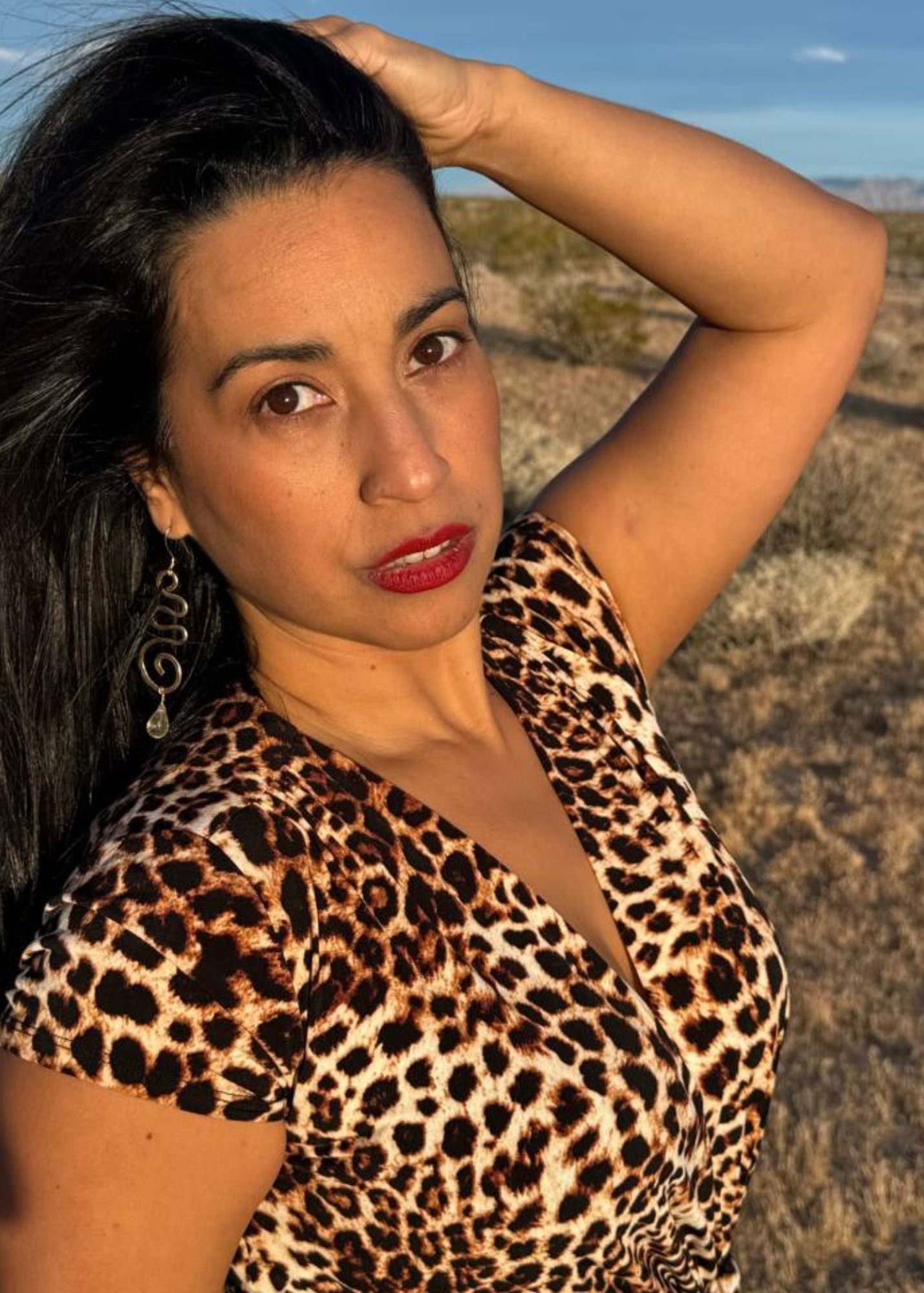 Jessy Furniel standing in the desert at golden hour, face forward, eyes closed, hair moving in the wind — representing the uncontrollable spirit of a powerful woman in pure joy to be loved for who she really is.